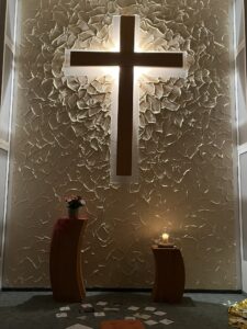 Altarraum mit Holzkreuz und Kerzen