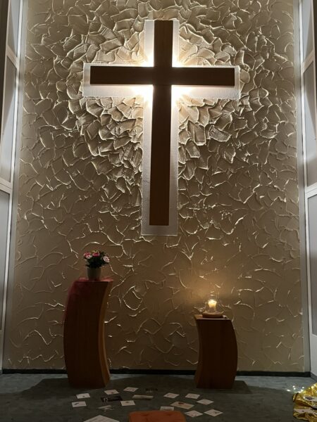 Altarraum mit Holzkreuz und Kerzen